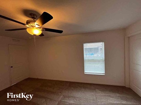 a living room with a ceiling fan and a window