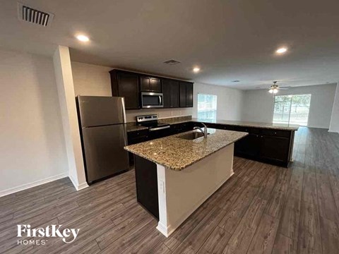 a kitchen with a granite counter top and a stainless steel refrigerator
