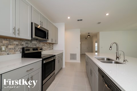 A kitchen with a stove top oven and microwave above it.