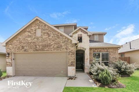 A house with a garage and a driveway in front.