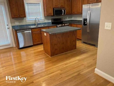 A kitchen with wooden cabinets and a stainless steel refrigerator.