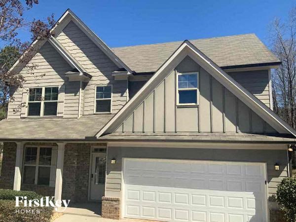 A house with a white garage door and a brick pillar.