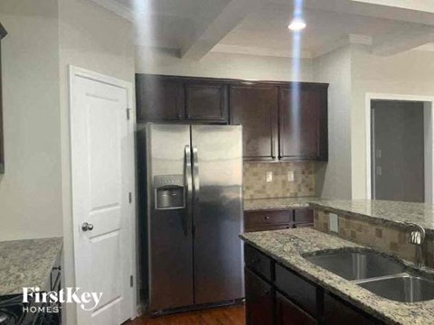 A kitchen with a stainless steel refrigerator and wooden cabinets.