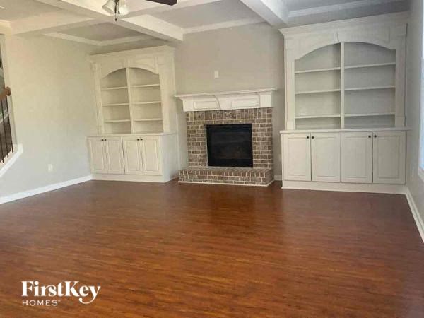 A living room with a fireplace and built-in cabinets.