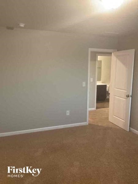 an empty living room with a door to a bathroom