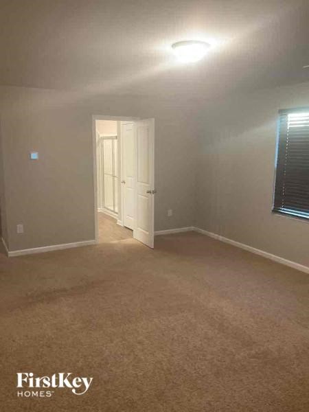 an empty room with a white door and a window