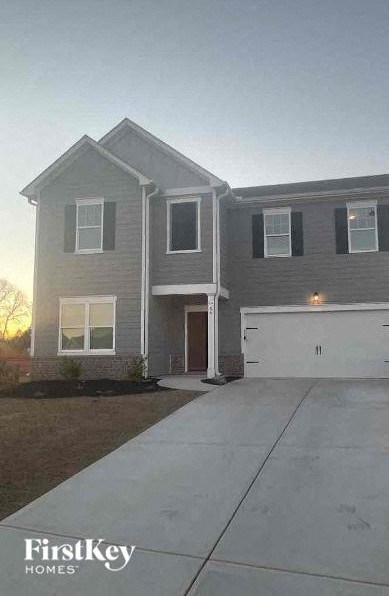 a gray house with a driveway and a white garage door