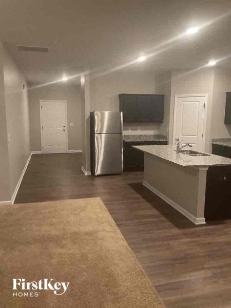 a kitchen with a stainless steel refrigerator and a sink