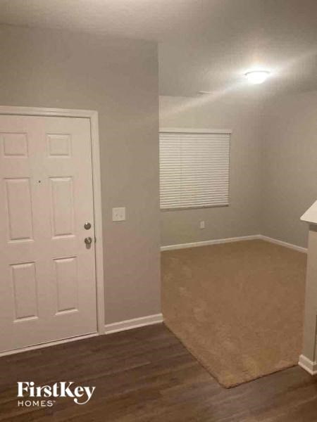 an empty room with a white door and a rug
