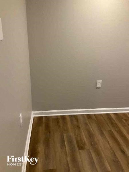 a empty room with a wooden floor and a white wall