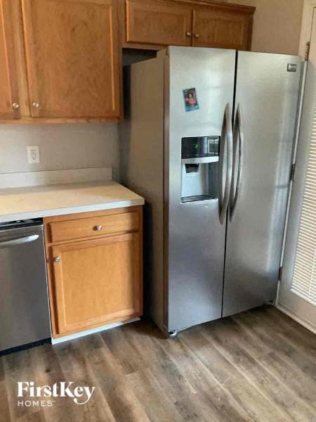 a kitchen with a stainless steel refrigerator and wooden cabinets