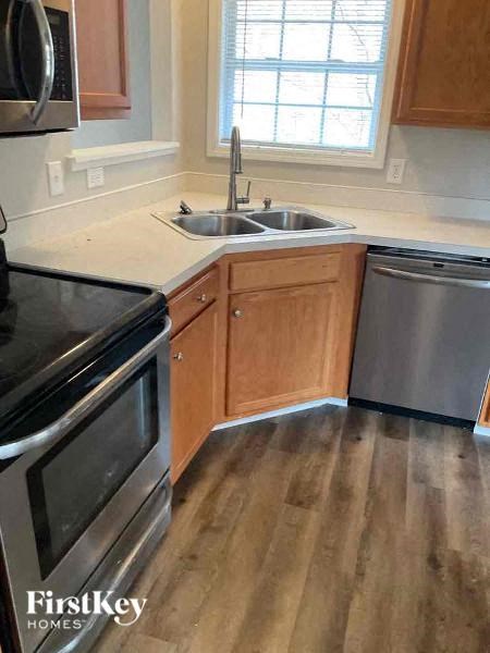 a kitchen with stainless steel appliances and wooden floors