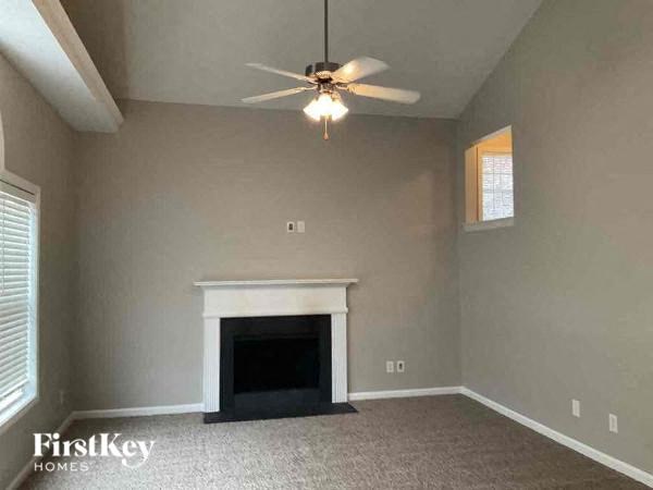 a living room with a fireplace and a ceiling fan
