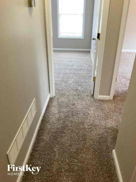 a hallway with a carpeted floor and an open door