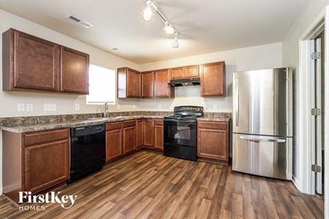 A kitchen with wooden cabinets and a stainless steel refrigerator.