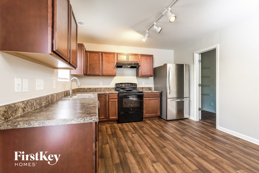 A kitchen with wooden cabinets and a stove top oven.
