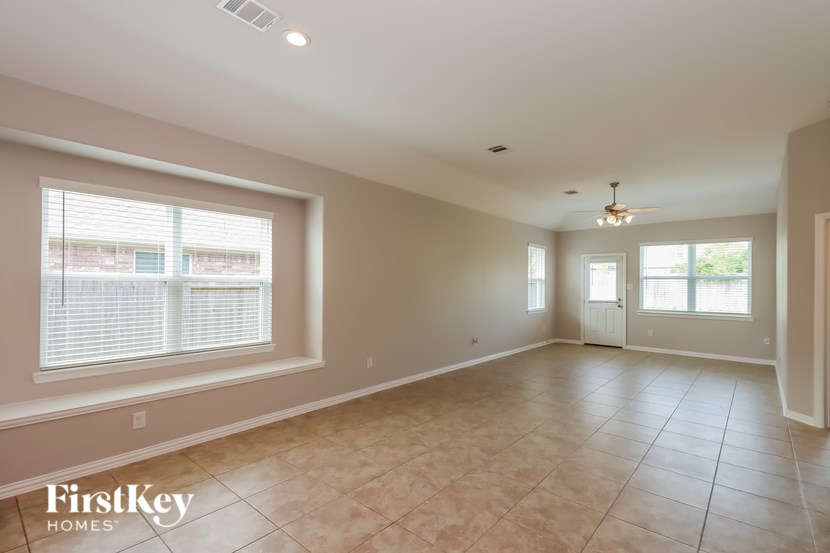 A spacious room with a tiled floor and a ceiling fan.