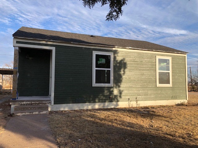 a small green house with a door and a window