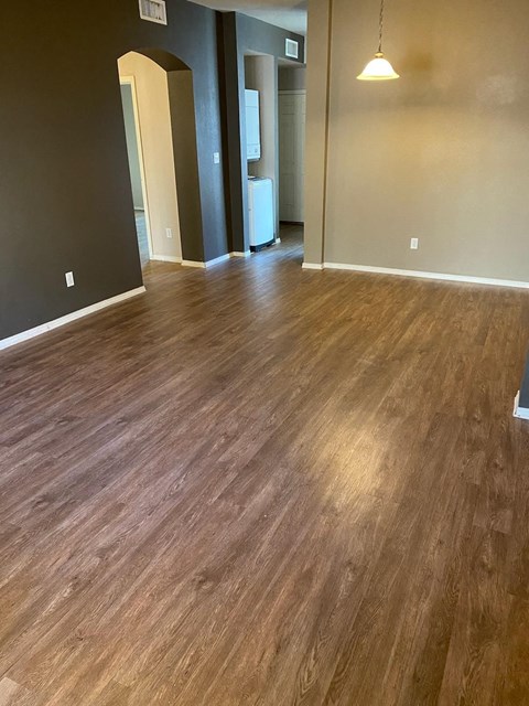 A room with wooden flooring and a light hanging from the ceiling.
