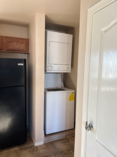 A black refrigerator is next to a white dishwasher in a kitchen.