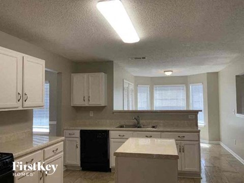 a large kitchen with white cabinets and a sink