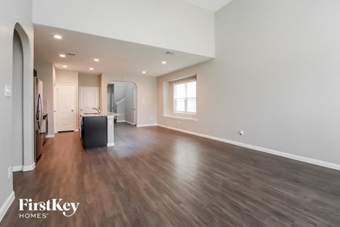 A spacious room with wooden flooring and a large mirror on the wall.