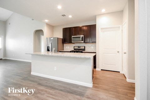 A kitchen with a white counter and wooden cabinets.