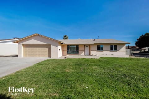 a beige house with a lawn in front of it