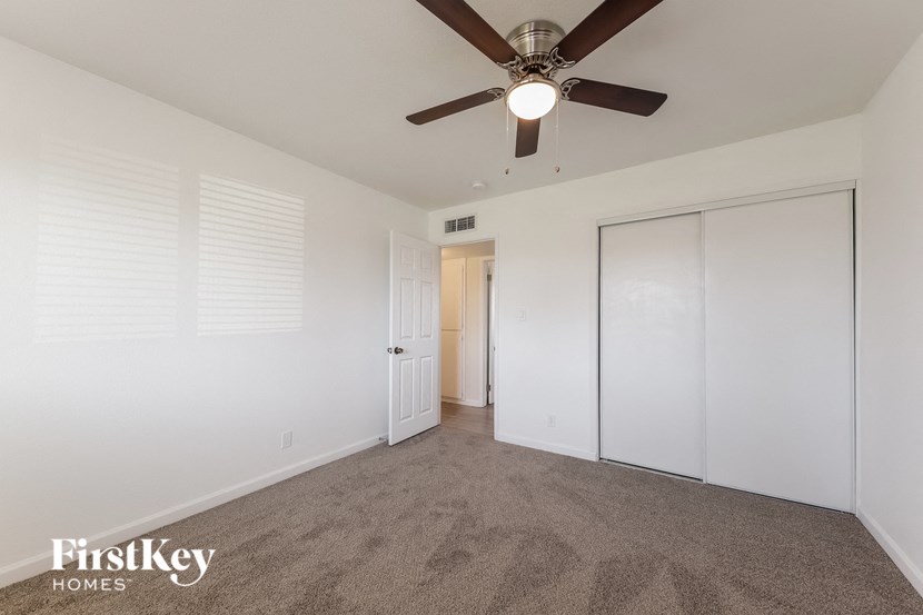 a living room with carpet and a ceiling fan