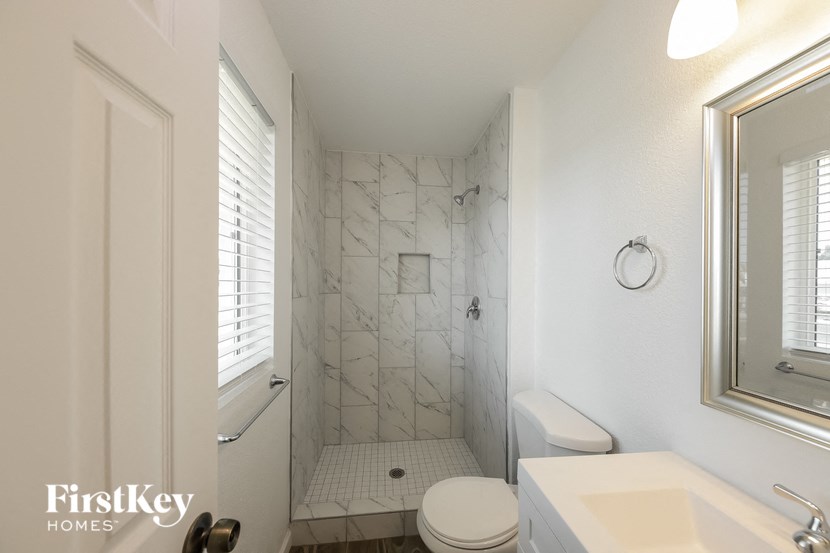 a white bathroom with a shower toilet and sink