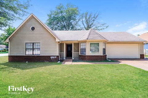 A house with a well-kept lawn in front of it.