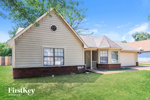 A house with a well-kept lawn in front of it.