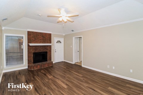 A room with a fireplace and a ceiling fan.