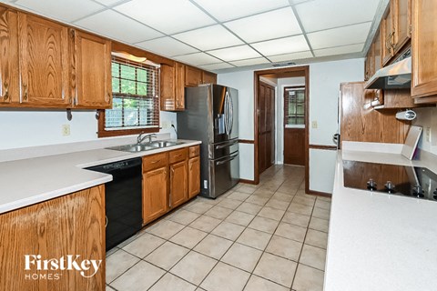 A kitchen with wooden cabinets and a refrigerator.