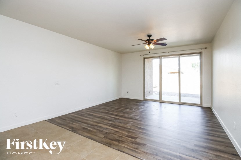 A room with wooden flooring and a ceiling fan.