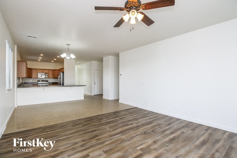 A spacious room with a ceiling fan and wooden flooring.