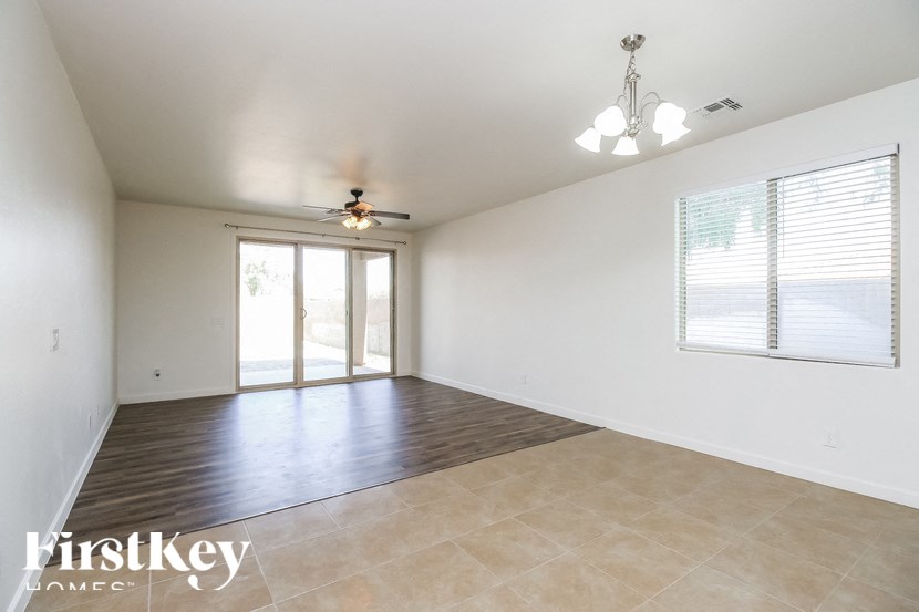 A spacious room with a ceiling fan and sliding glass doors.