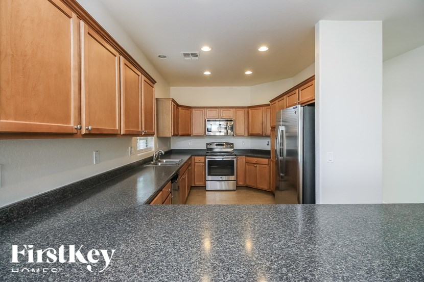 A kitchen with wooden cabinets and a granite countertop.