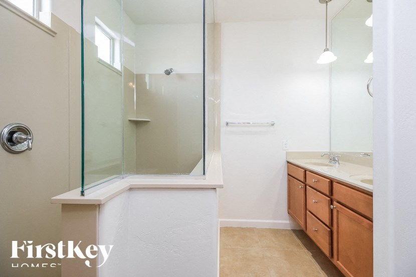 A bathroom with a glass shower door and a white sink.