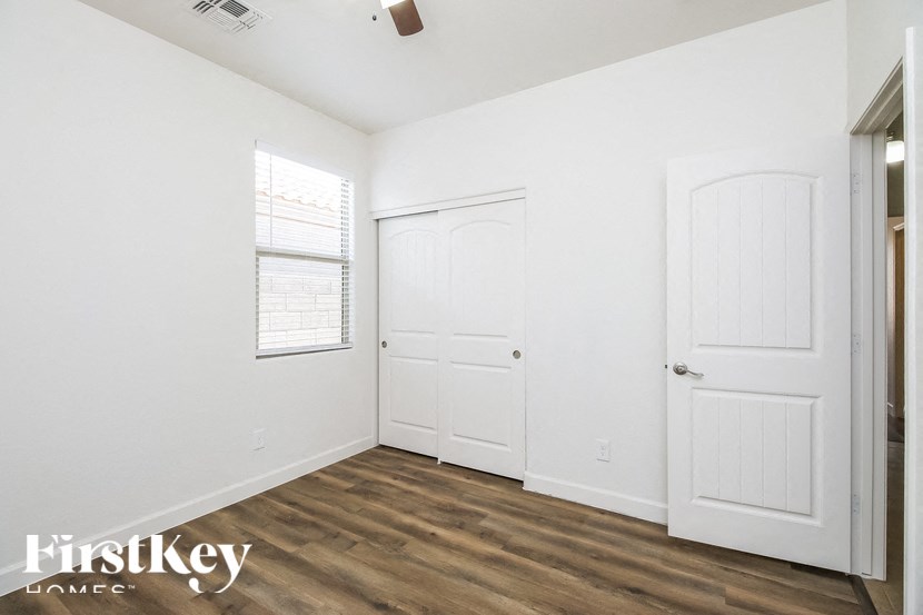 A room with a white door and a window with blinds.
