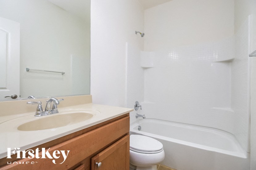 A white bathroom with a tub, sink and toilet.