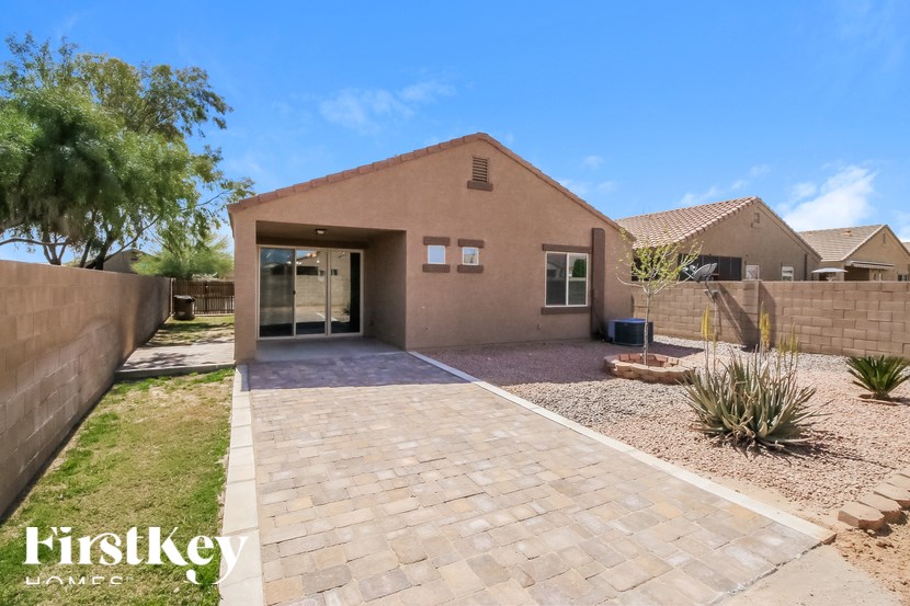 A house with a brown exterior and a brick driveway is for sale.