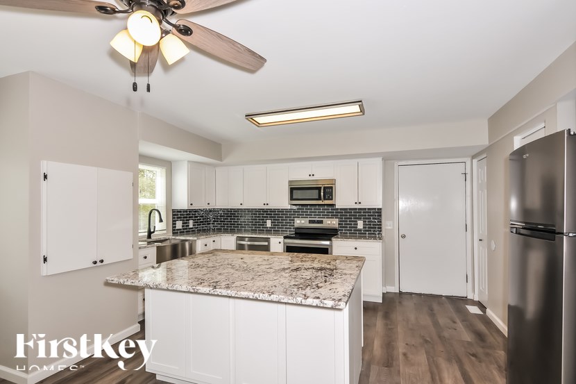 A kitchen with a marble countertop and stainless steel appliances.