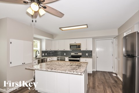 A kitchen with a marble countertop and stainless steel appliances.