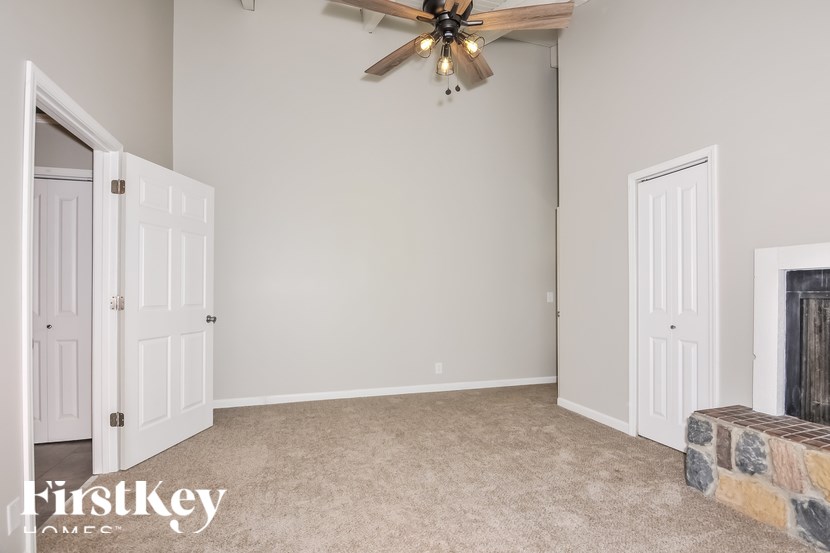 A room with a fireplace and a ceiling fan.