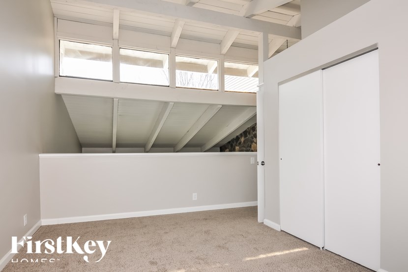 A white room with a carpeted floor and a white closet.