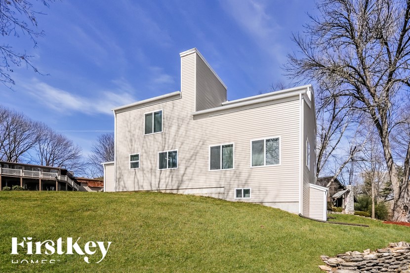 A modern house with a flat roof and a chimney is showcased in the image.