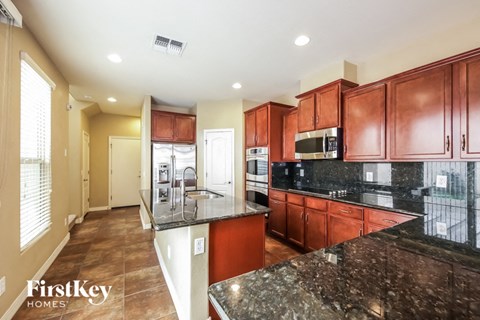 a kitchen with granite counter tops and wooden cabinets