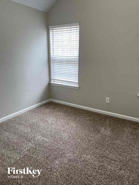 an empty room with carpet and a window