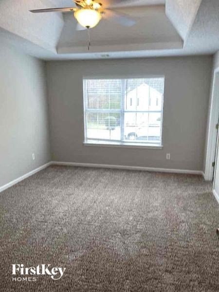 an empty room with a ceiling fan and a window